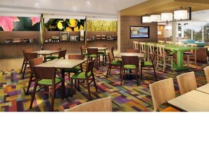 A hotel lobby with multiple seating areas, a reception desk, and a television screen. - Fairfield Inn & Suites by Marriott Gaylord (Gaylord)