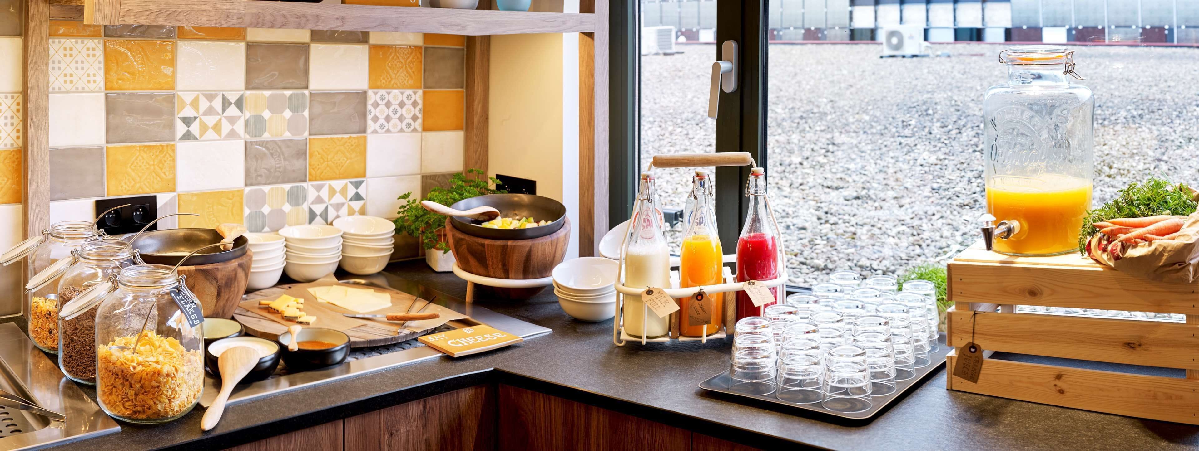 Un buffet de petit-déjeuner proposant une variété d’aliments, une machine à café et un distributeur de jus.