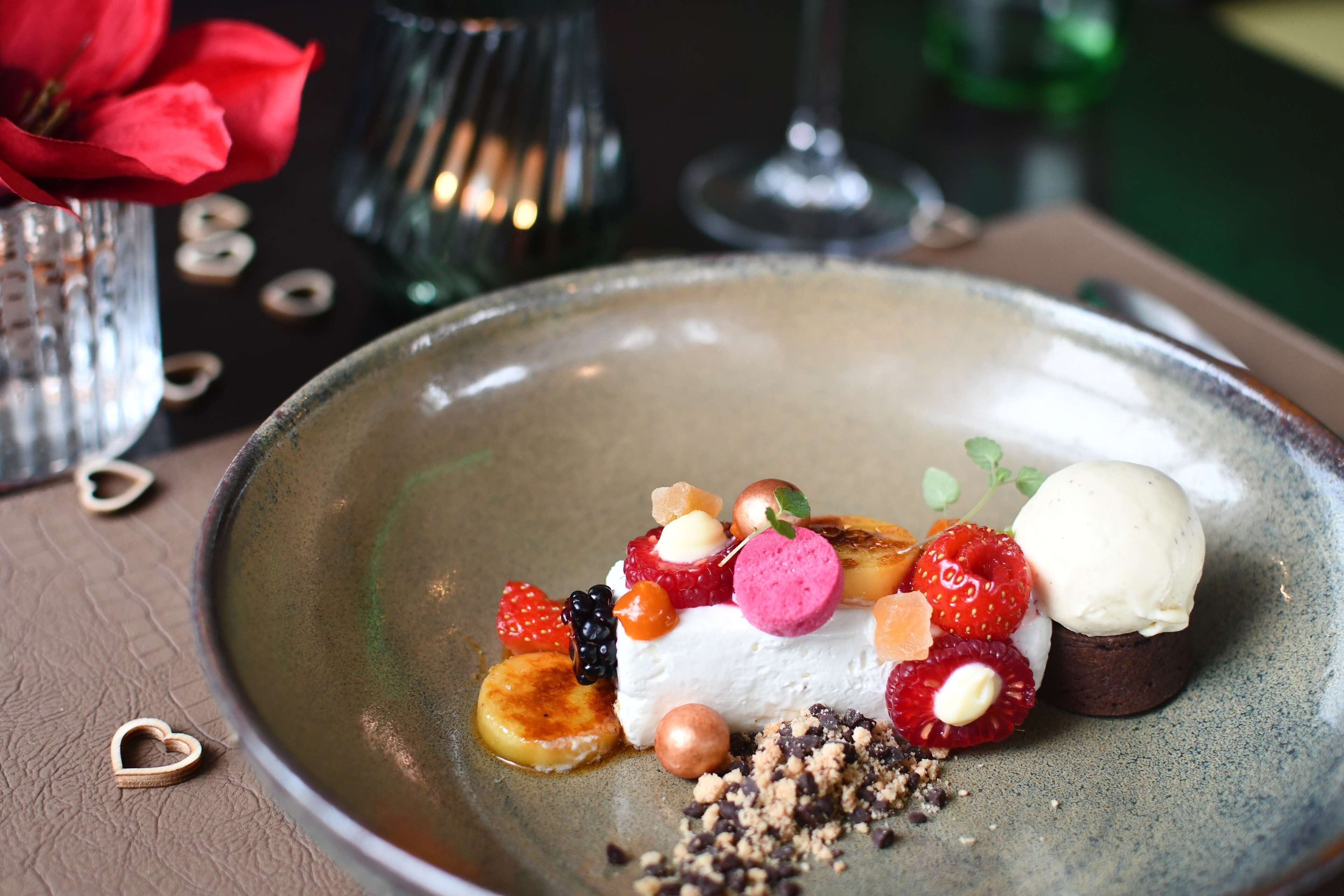 A dessert plate with various fruits and a scoop of ice cream.
