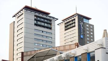 A modern hotel with a flat roof, multiple floors, and a prominent sign.