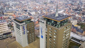 Two high-rise buildings with modern architecture, featuring prominent signage and a flat roof design. - Park Inn by Radisson Hasselt (Hasselt)
