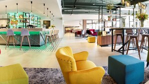 A modern hotel lobby with a bar area, seating arrangements, and a reception desk. - Park Inn by Radisson Hasselt (Hasselt)