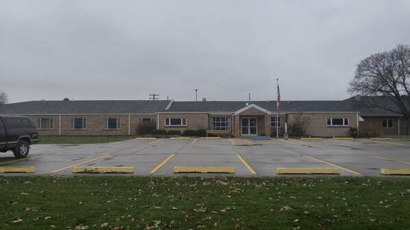 A building with a parking lot and a flag.