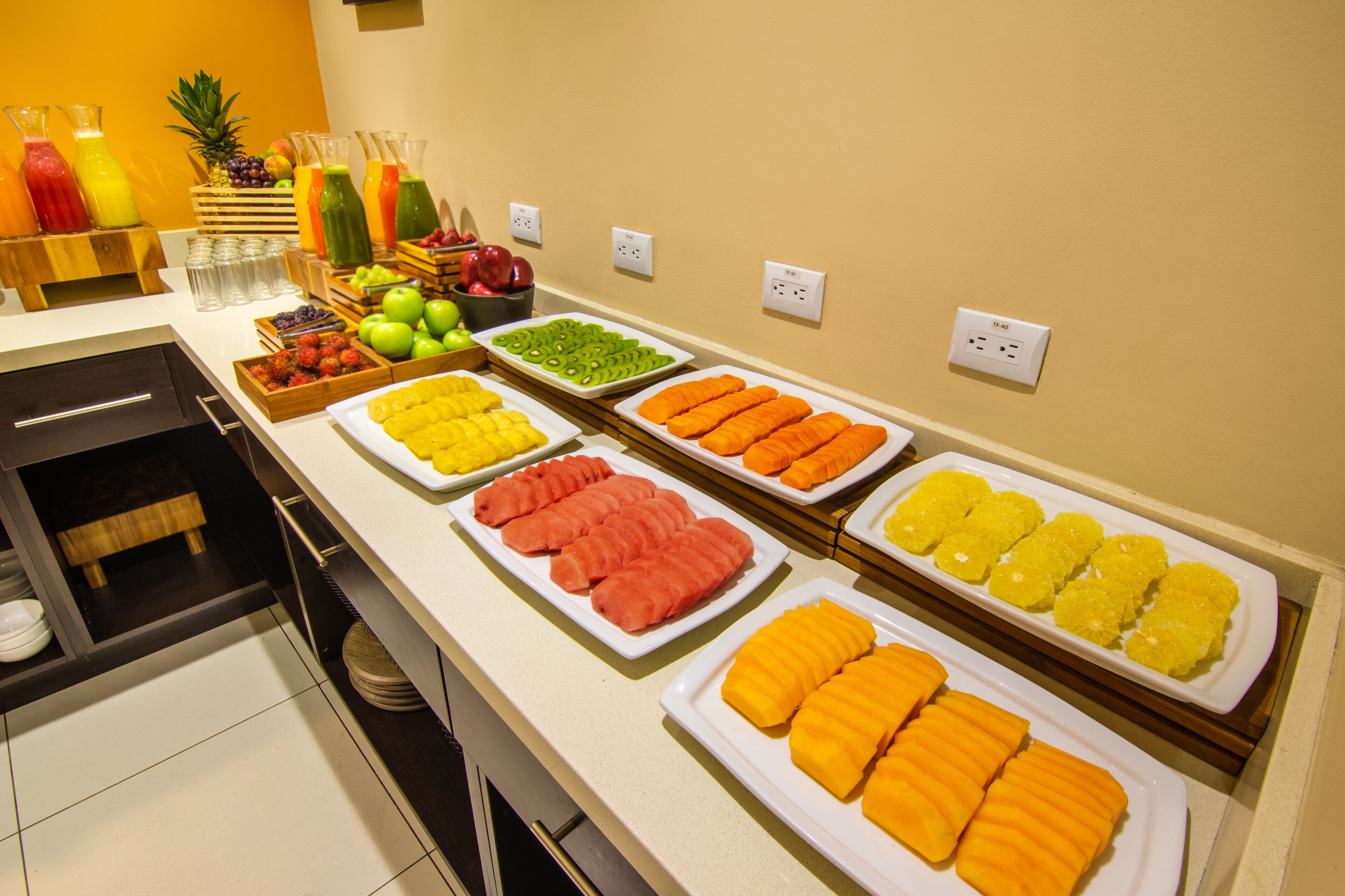 A buffet with various fruits and juices.