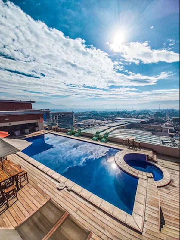 Una piscina al aire libre, sombrillas, tumbonas