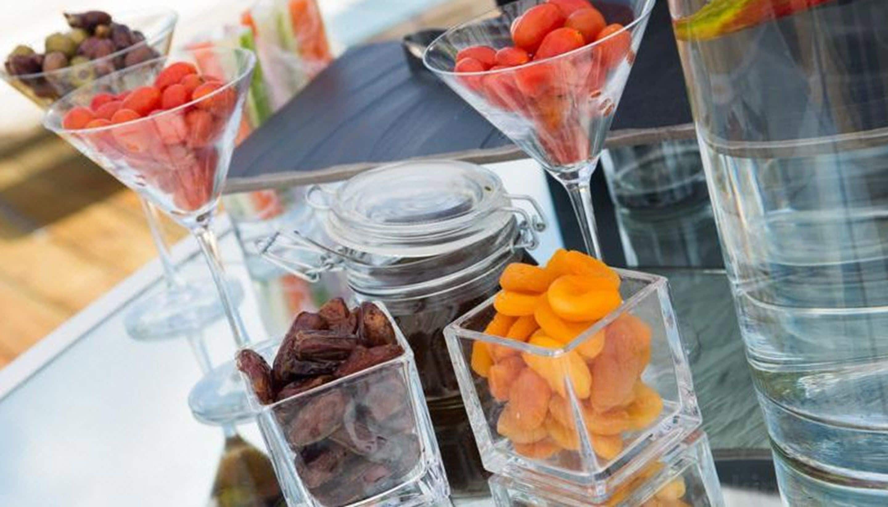 A glass display case with various snacks and a jar of dried fruits.