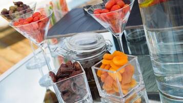 A glass display case with various snacks and a jar of dried fruits.
