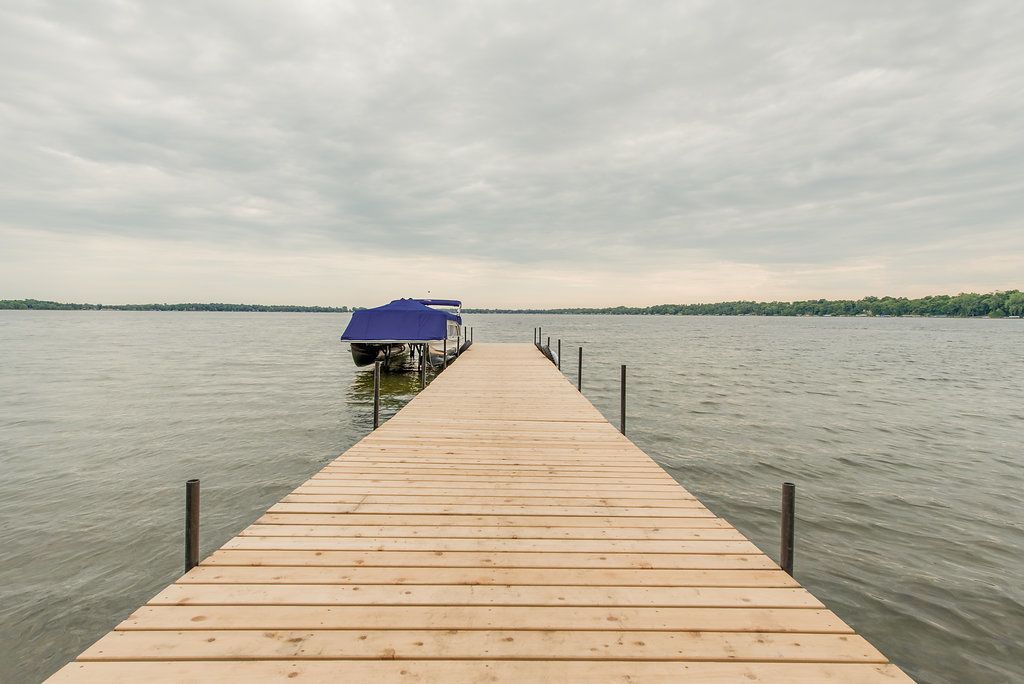 A wooden pier extending into a body of water with a covered structure at the end.