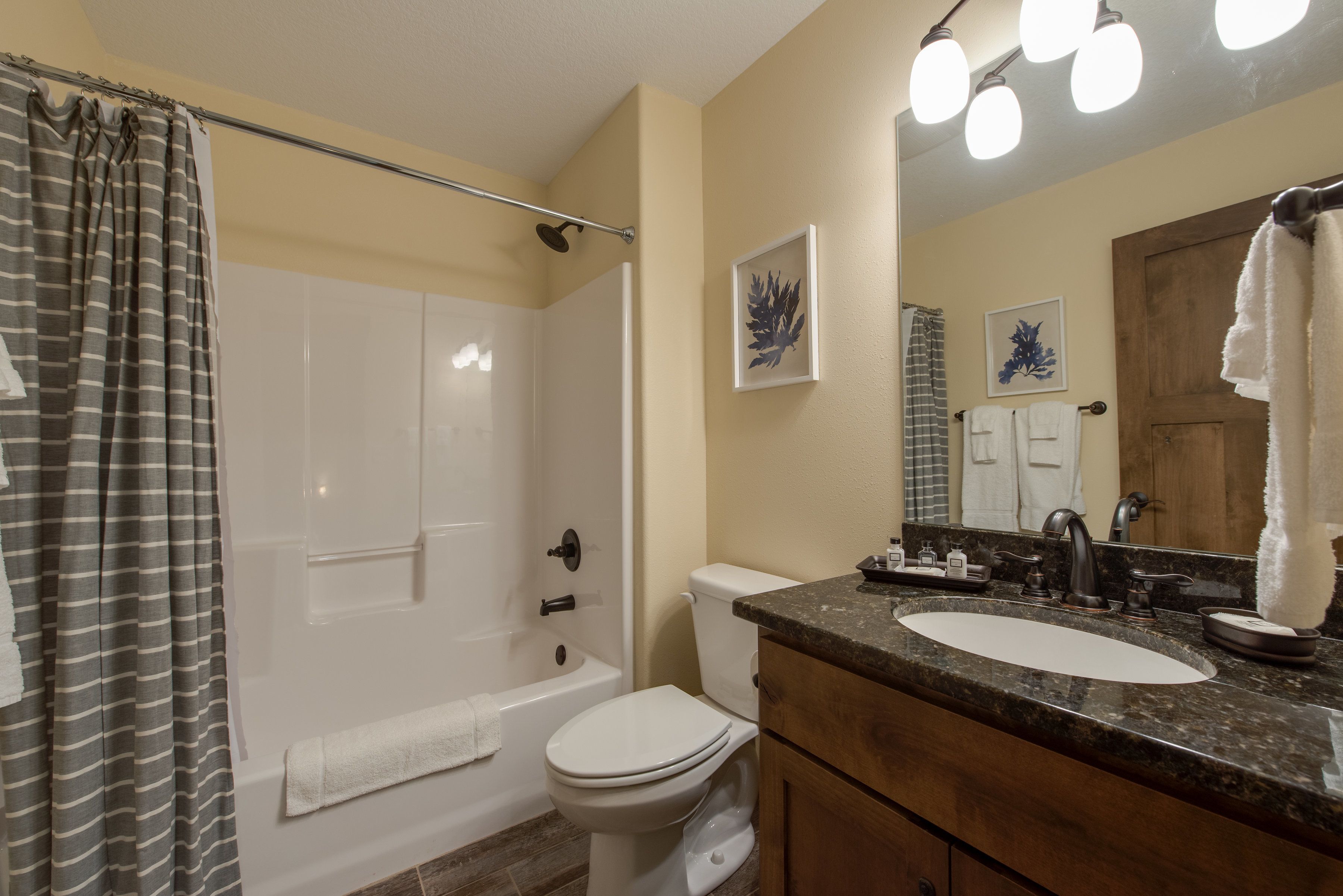 A bathroom with a bathtub, toilet, sink, and vanity.