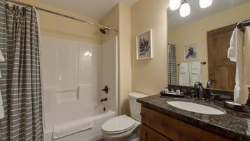 A bathroom with a bathtub, toilet, sink, and vanity.