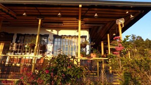 A traditional Japanese-style building with a covered porch, large windows, and a bell tower. - Hostal Finca Cardonales (Salento)