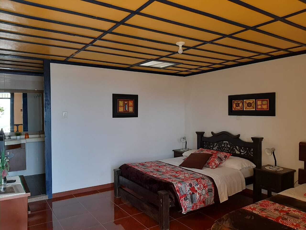 A bedroom with a bed, a nightstand, a bedside table, and a ceiling fan.