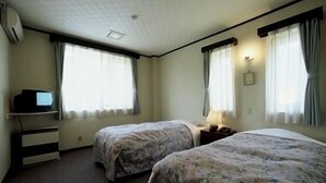 A room with two beds, a TV, and a desk. - Guesthouse Hilltop (Kiso)
