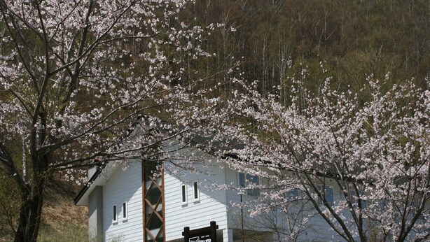 A white building with a sign that reads "The Hilltop Inn." - Guesthouse Hilltop (Kiso)