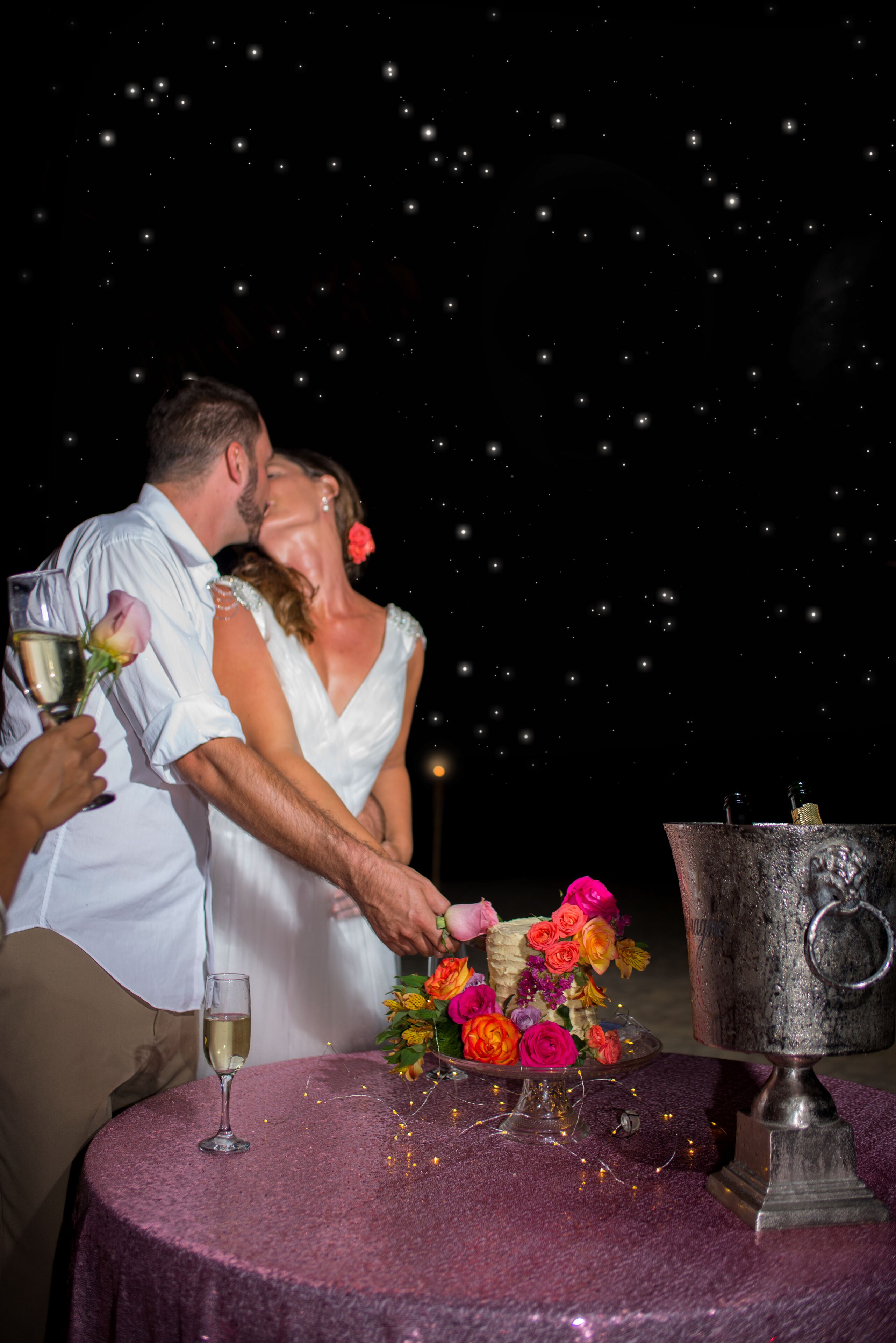 Una pareja besándose en una mesa con un fondo de noche estrellada.