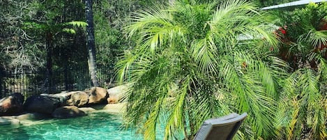 Una piscina al aire libre, sillones reclinables de piscina