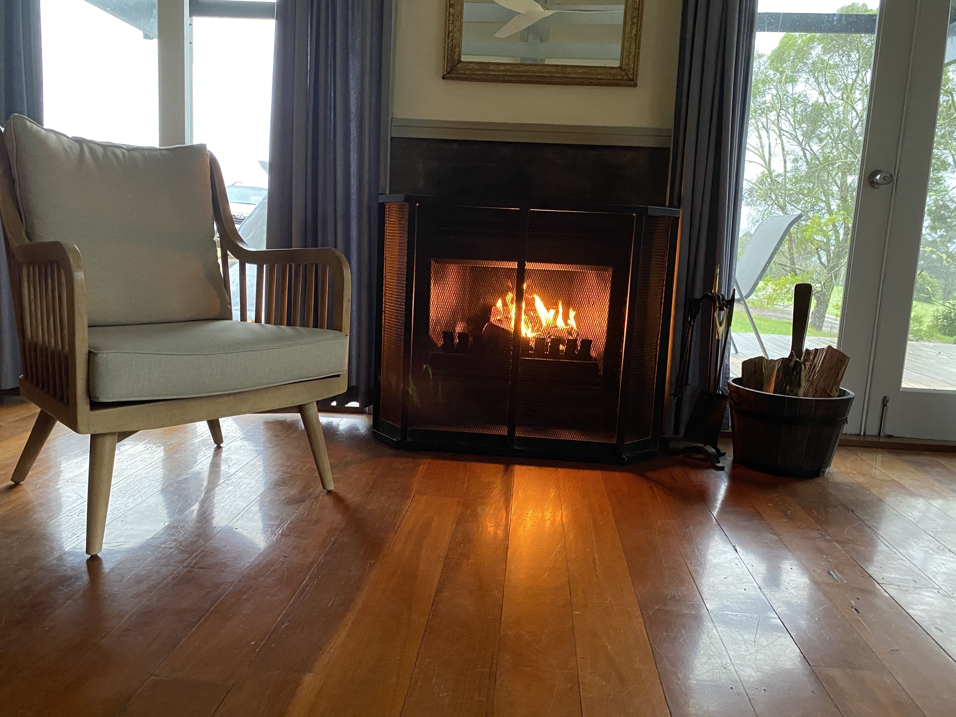 Una sala de estar con chimenea, un sofá y vistas al exterior.