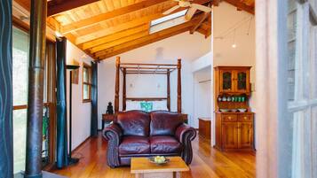 Una habitació acollidora amb un sostre de fusta, un sofà de cuir, un taula de fusta amb una safata i un armari de fusta.