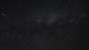 A house with a large open porch under a starry night sky.