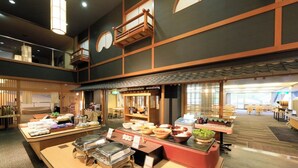 Een buffetgedeelte met diverse themastations en een zithoek met tafels en stoelen.