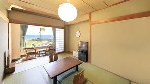 A traditional Japanese room with tatami flooring, a low table, and a television. - Bousou Shirahama Umisato Hotel (Minamiboso)