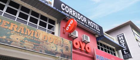 A hotel with a sign for 'Corridor Hotel' and a large 'OYO' sign.