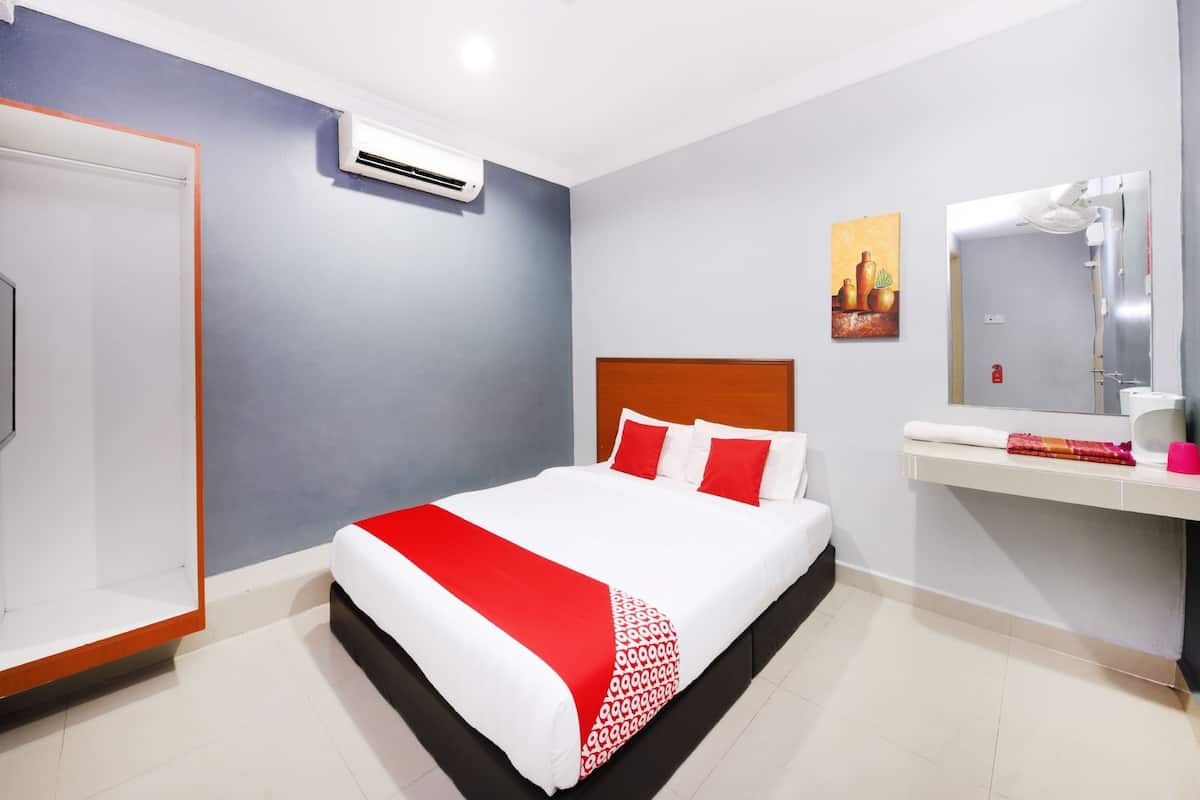 Une chambre d’hôtel avec un lit, un miroir dans la salle de bain et un climatiseur fixé au mur.