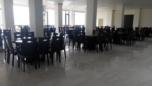 A spacious indoor area with rows of tables and chairs, large windows, and white pillars. - Tai An Cingjing (Zhushan)