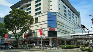 A modern multi-story building with a prominent Orchard Point sign, large windows, and a pedestrian entrance.