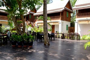 A wooden deck with outdoor seating and potted plants.