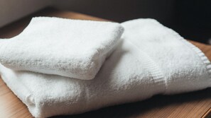 Two white towels stacked on a wooden surface. - KEIKYU EX INN Higashiginza (Tokyo)