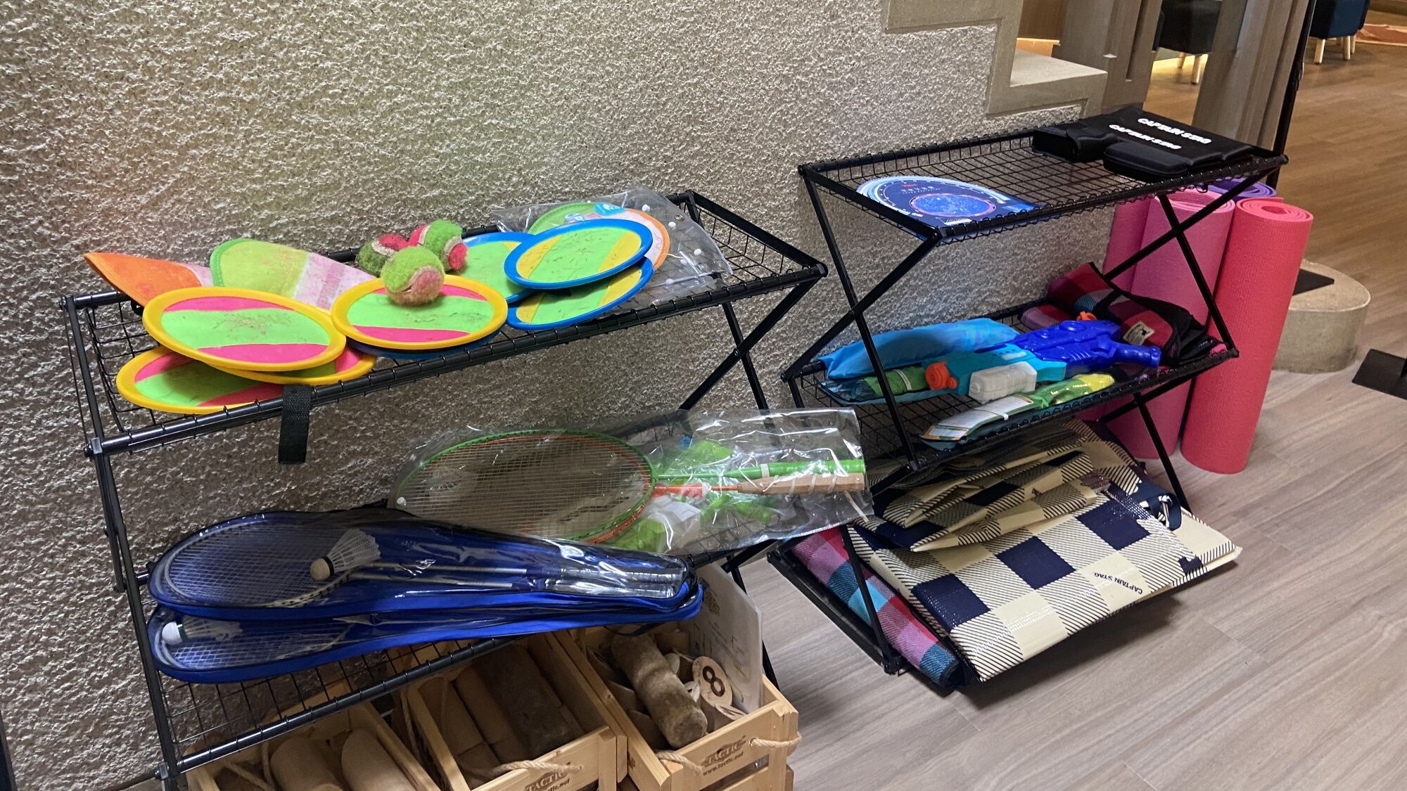Se exhiben esteras de colores y equipo deportivo, incluyendo una estera azul y un soporte con varios artículos.