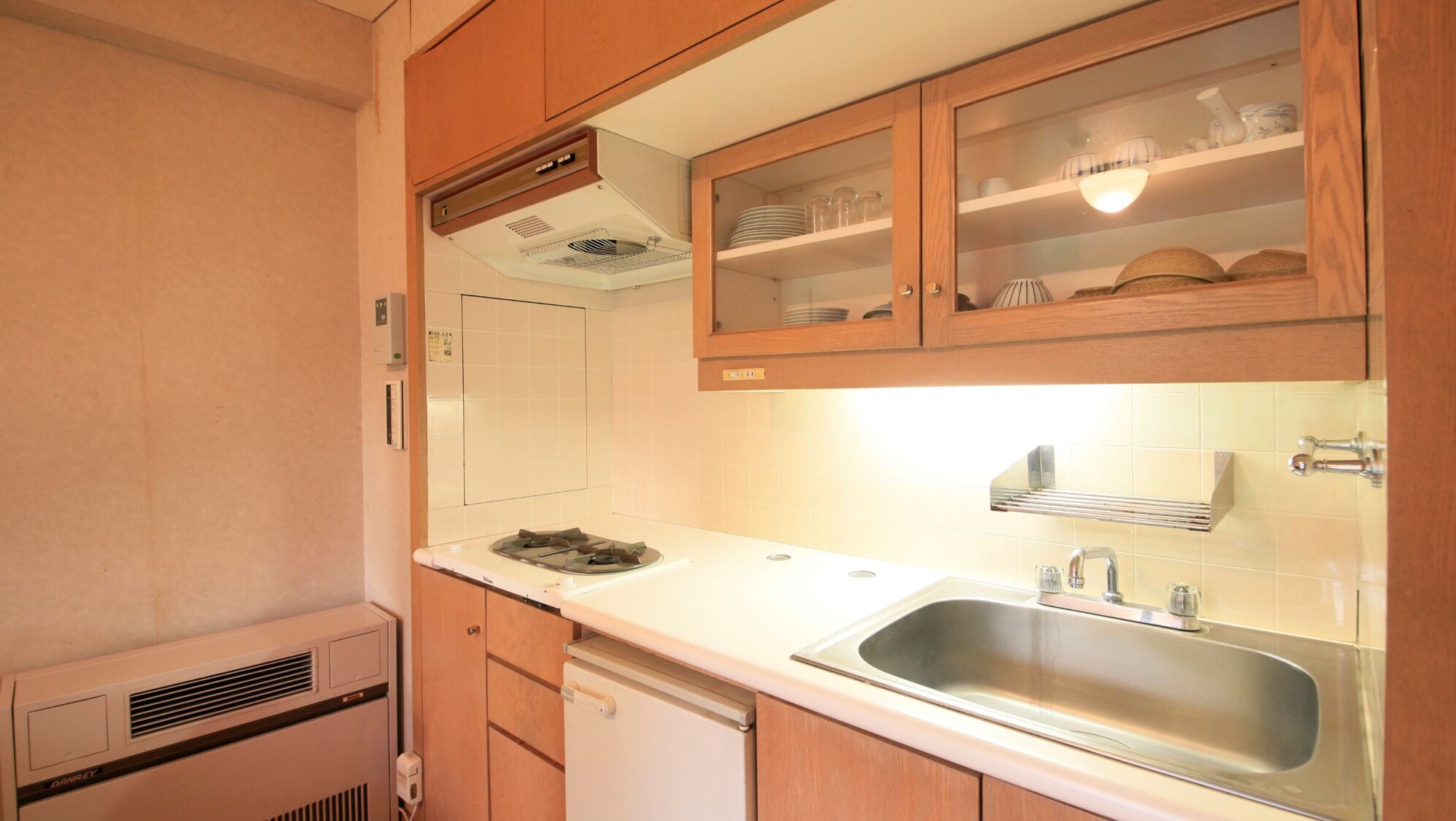 A compact kitchen with a sink, stove, and cabinets.