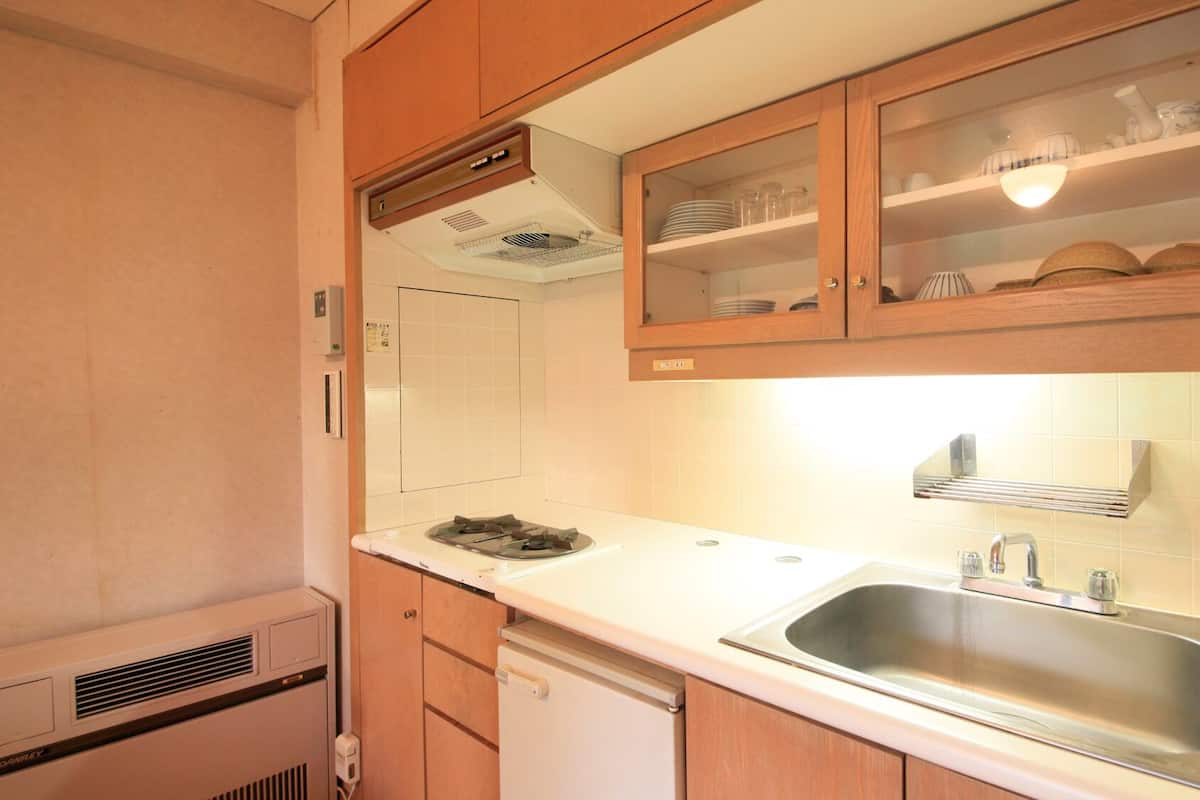 Une cuisine compacte avec des meubles en bois, un évier en acier inoxydable et une cuisinière intégrée.