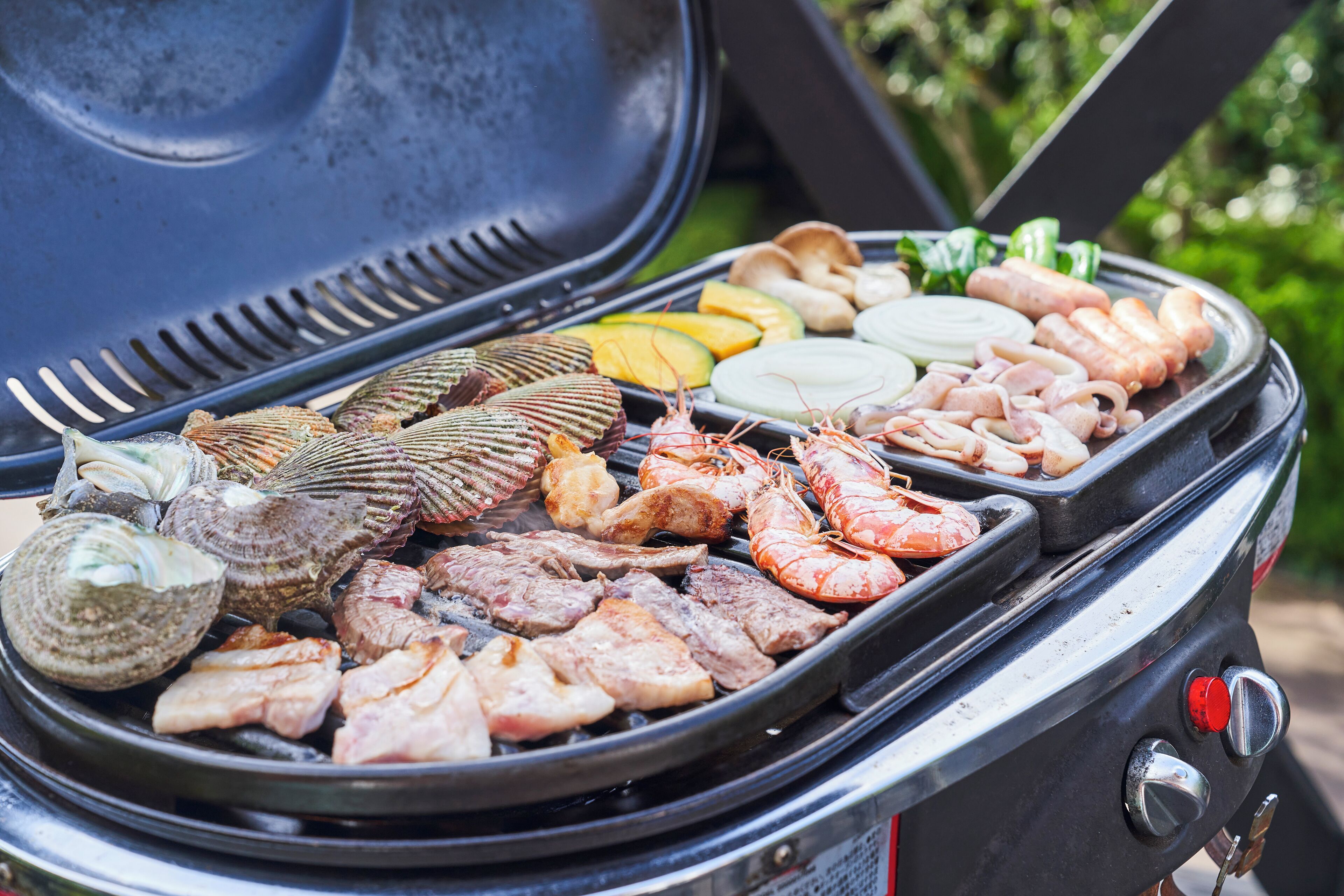 A grill with various meats and seafood.