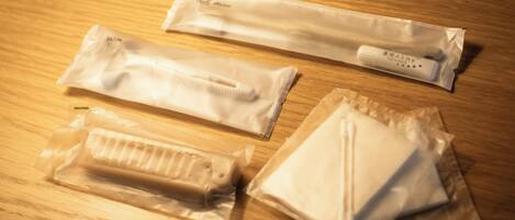 Quatro embalagens de produtos de higiene bucal sobre uma superfície de madeira.