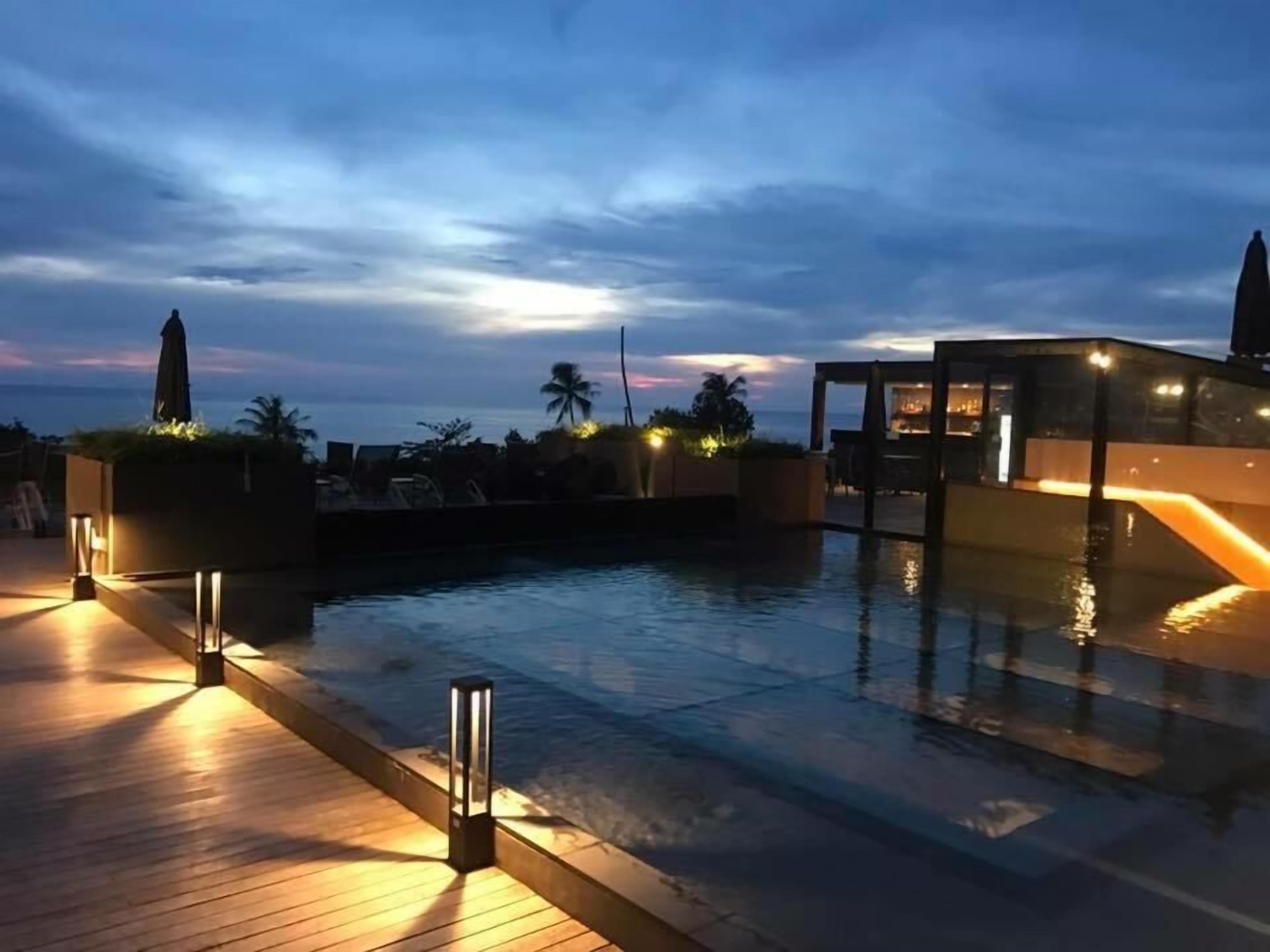 Una piscina al aire libre, sombrillas, tumbonas