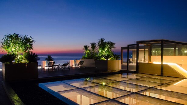 A rooftop terrace with a glass floor, seating area, and a glass-enclosed structure. - The Erawan Koh Chang (Ko Chang)
