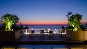 A poolside area with lounge chairs and a view of the ocean at dusk. - The Erawan Koh Chang (Ko Chang)