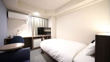 A hotel room with a bed, a desk with a chair, a television, and a small table.
