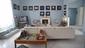 A living room with a sofa, a coffee table, a fireplace, and framed pictures on the wall. - B&B Cuore di Napoli (Naples)