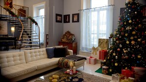 A living room with a white sofa, a Christmas tree, and a staircase. - B&B Cuore di Napoli (Naples)