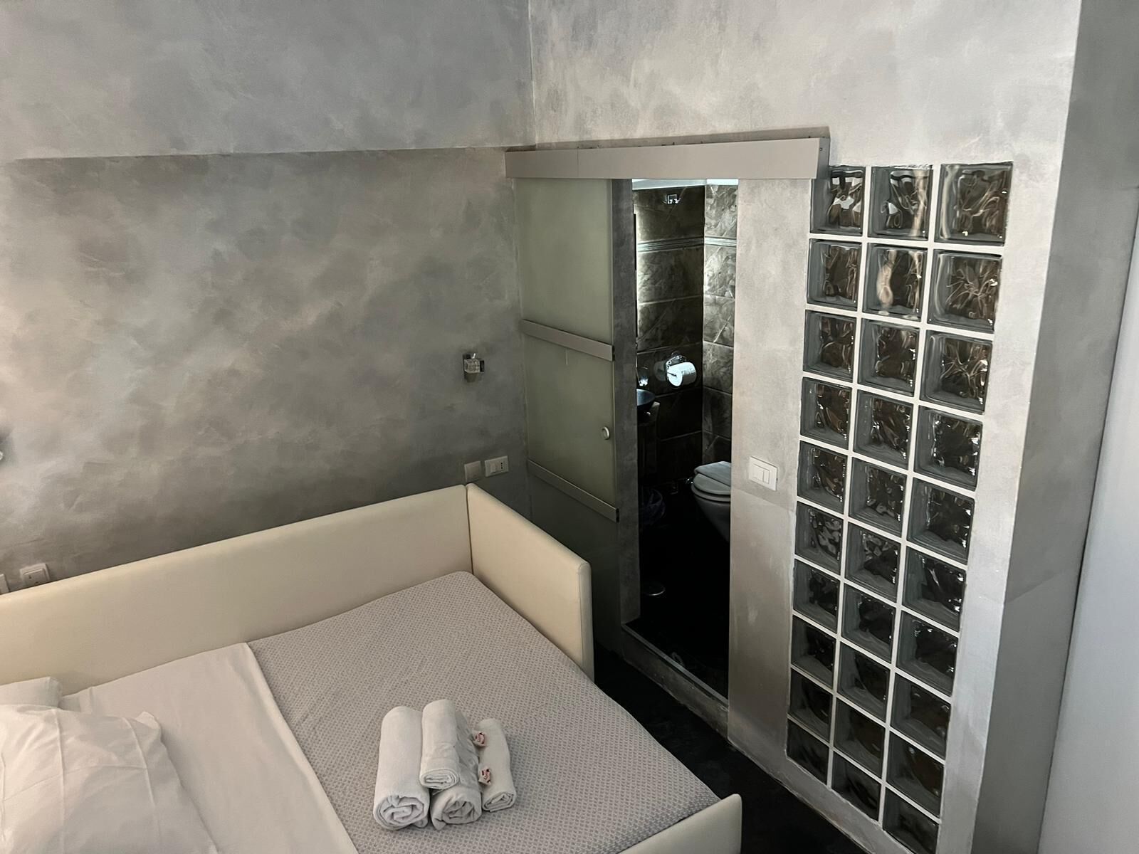A modern bathroom with a large mirror, a bathtub, and a shower area.