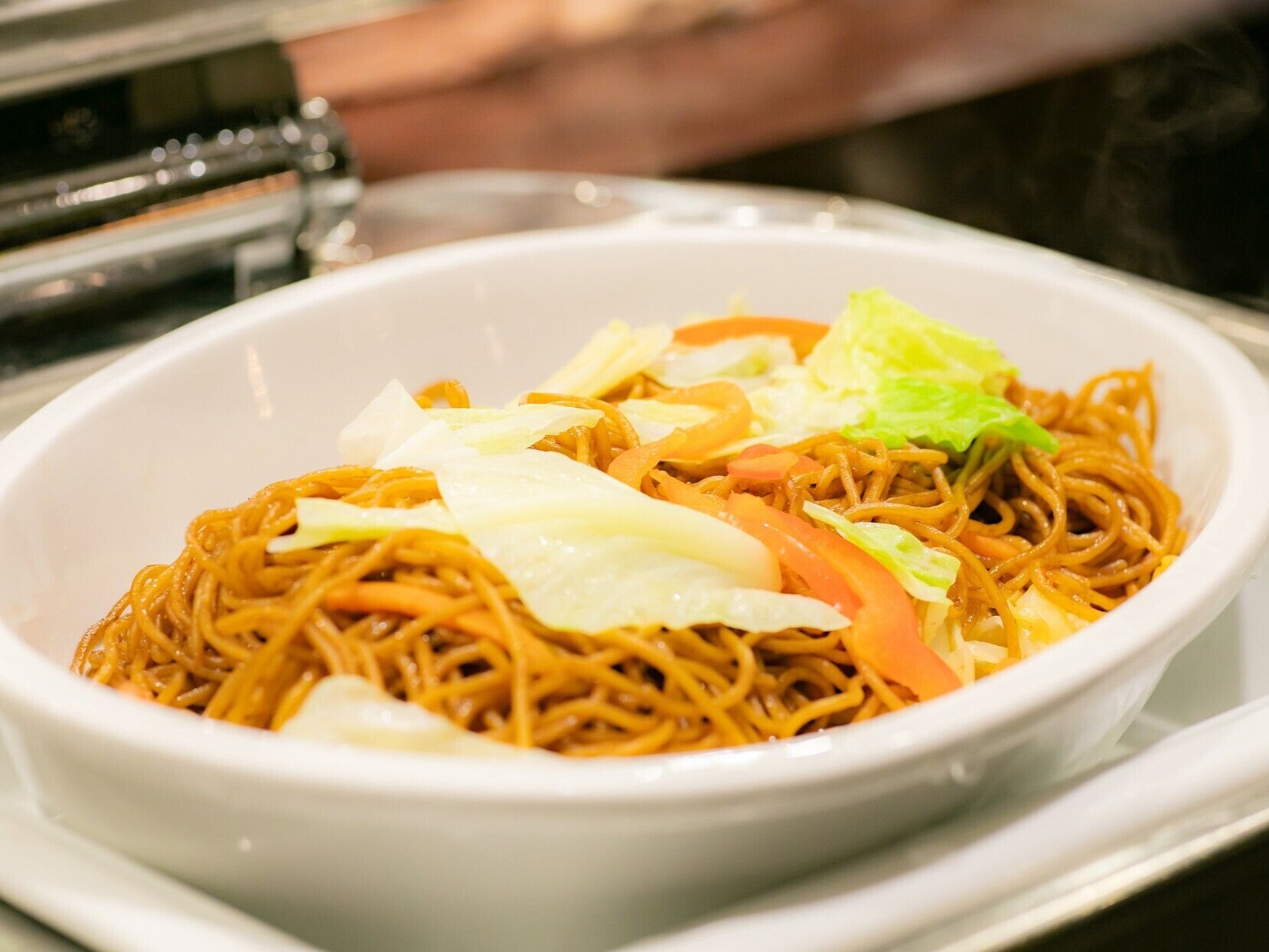 A bowl of noodles with vegetables and a slice of cheese.