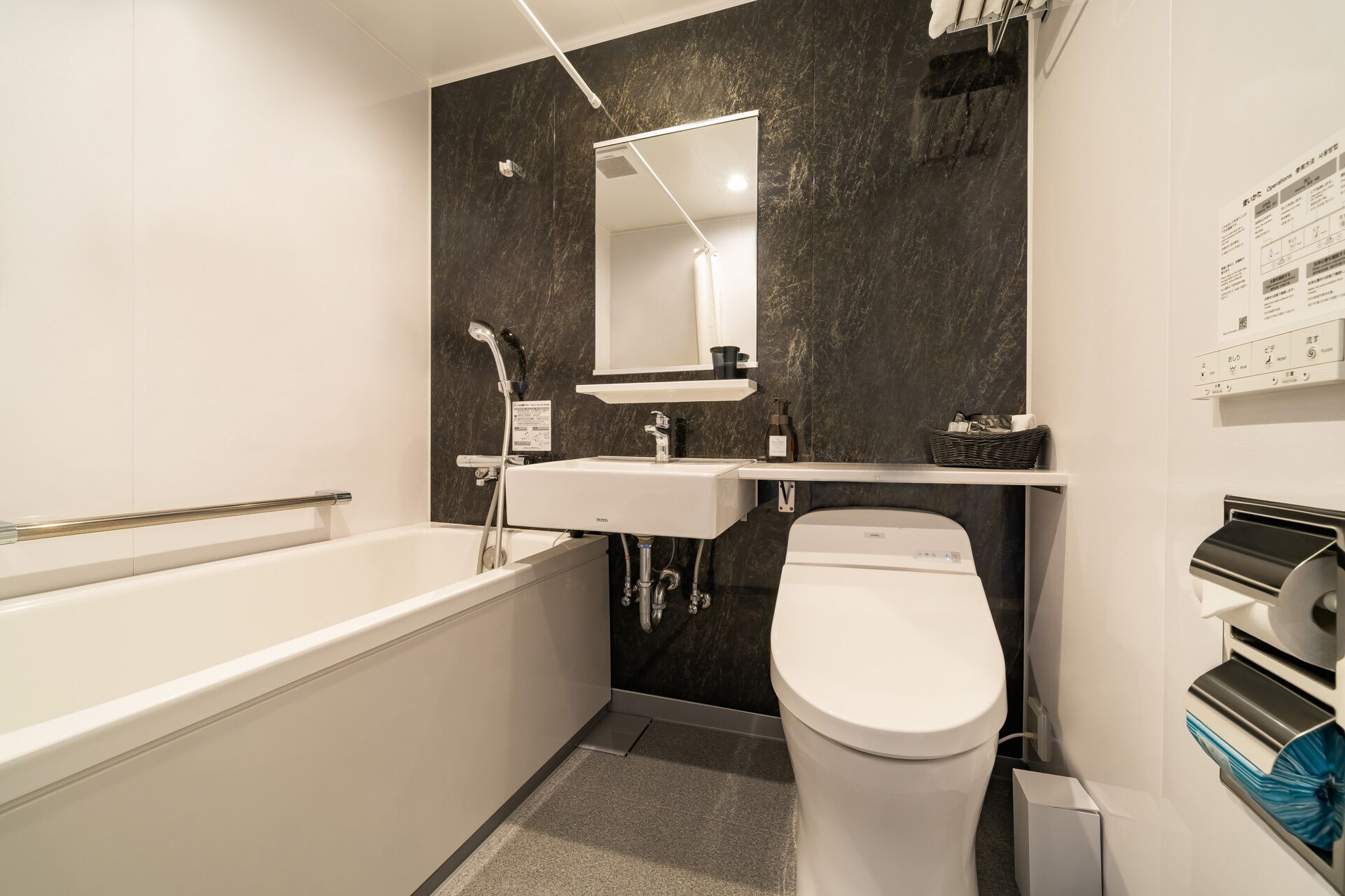 A compact bathroom with a bathtub, a sink, a toilet, and a mirror.