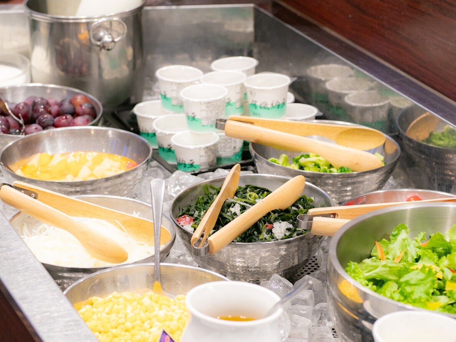 A buffet with various food items and utensils.