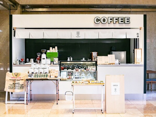 Un café où l’on peut voir, derrière le comptoir, différents types de grains de café et divers équipements.