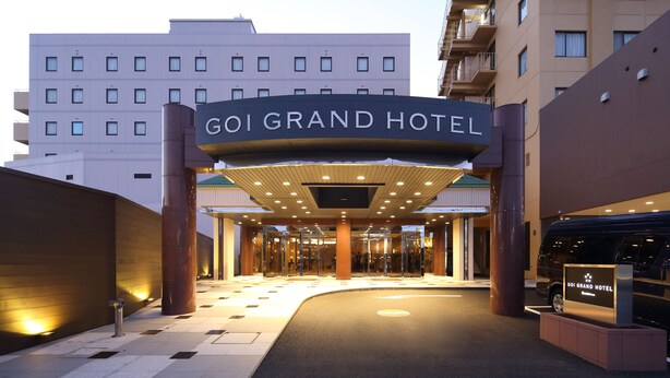 La entrada al GOI GRAND HOTEL, con un diseño moderno, que presenta un cartel grande y una zona de acceso cubierta.