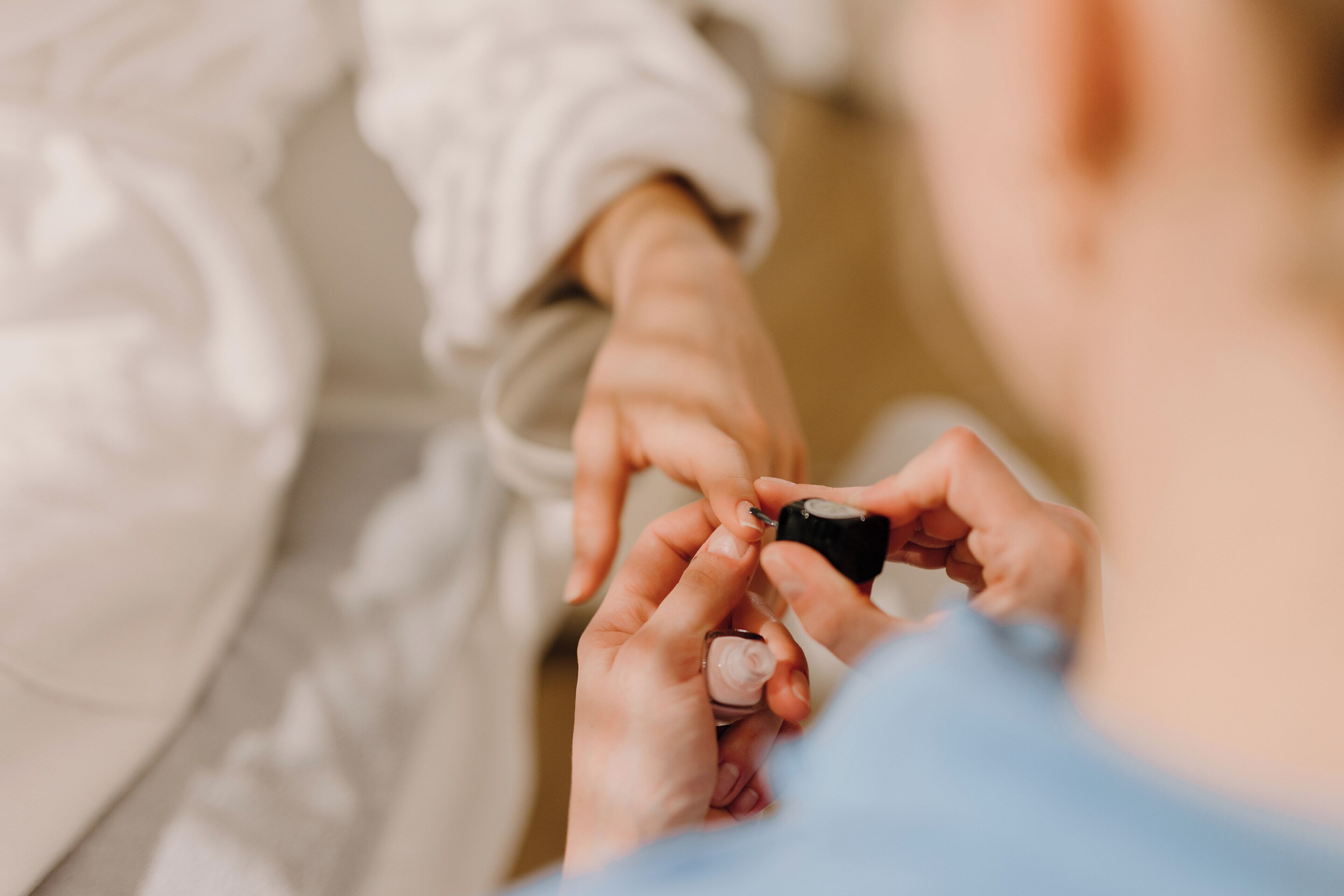 Una persona aplicando esmalte de uñas.
