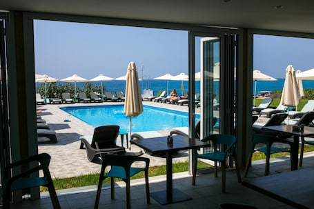 Una piscina al aire libre, sombrillas, sillones reclinables de piscina